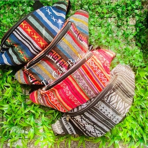 Puede incluir: Cuatro riñoneras tejidas de tela colorida con correas negras. Las riñoneras tienen diferentes patrones y colores, incluyendo azul, rojo, amarillo y negro.