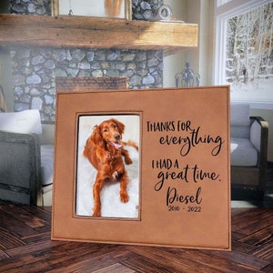 May include: A brown leather photo frame with a picture of a red dog inside. The frame has the text "Thanks for everything. I had a great time. Diesel 2010 - 2022" engraved on it.