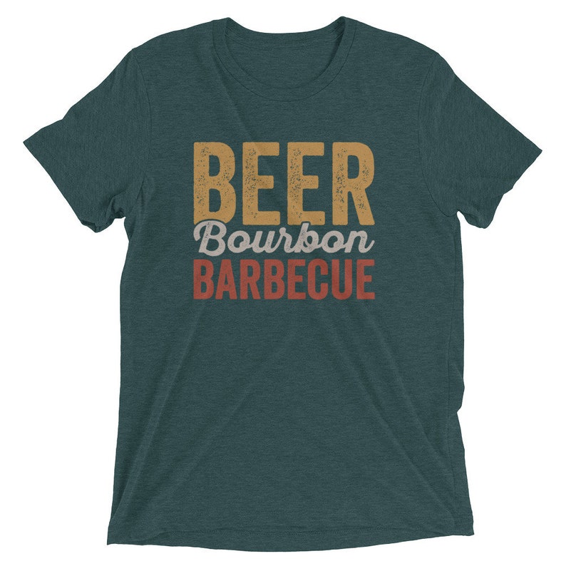 May include: A teal blue t-shirt with the text "BEER Bourbon BARBEQUE" in a vintage style font. The text is in shades of yellow, orange, and red.