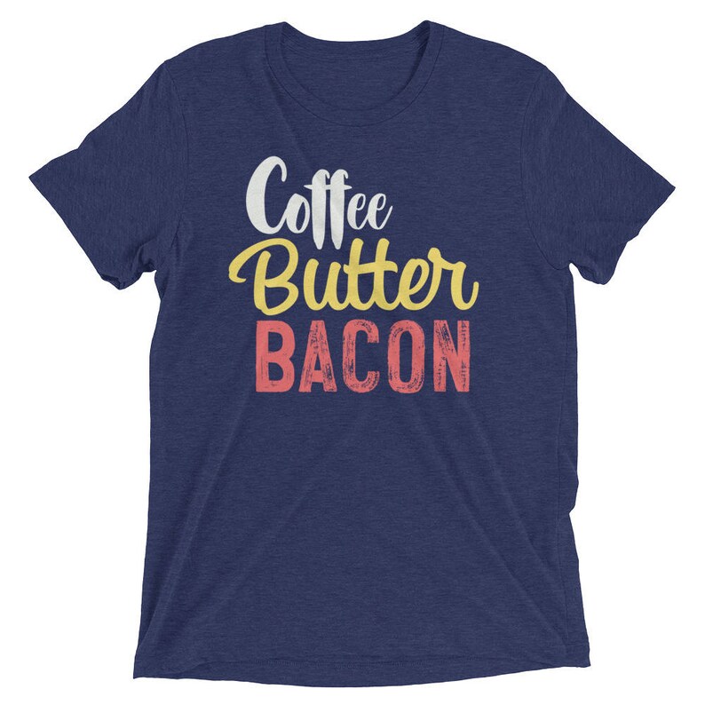 May include: A navy blue t-shirt with the text "Coffee Butter Bacon" in white, yellow, and pink lettering.