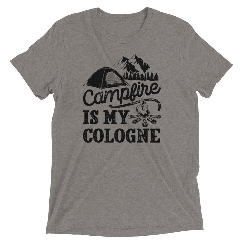 May include: A heather gray t-shirt with a black graphic of a tent, mountains, a campfire, and the text "Campfire is my cologne".