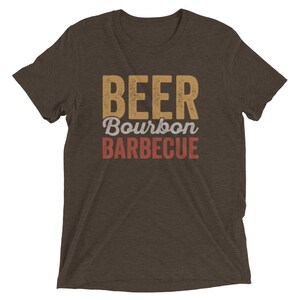 May include: A brown t-shirt with the text "BEER Bourbon BARBECUE" in a vintage style font.