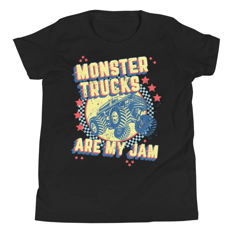 May include: Black youth t-shirt with a retro-style graphic of a monster truck. The graphic features a blue monster truck with yellow wheels and a red, white, and blue star pattern. The text "Monster Trucks Are My Jam" is printed in yellow, red, and blue.