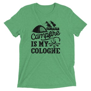 May include: Green t-shirt with a black graphic of a tent, campfire, and the text "Campfire is my cologne".