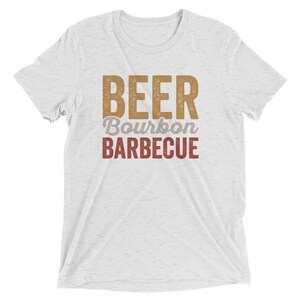 May include: White t-shirt with the text "BEER BOURBON BARBECUE" in a vintage style font. The text is in brown and red.