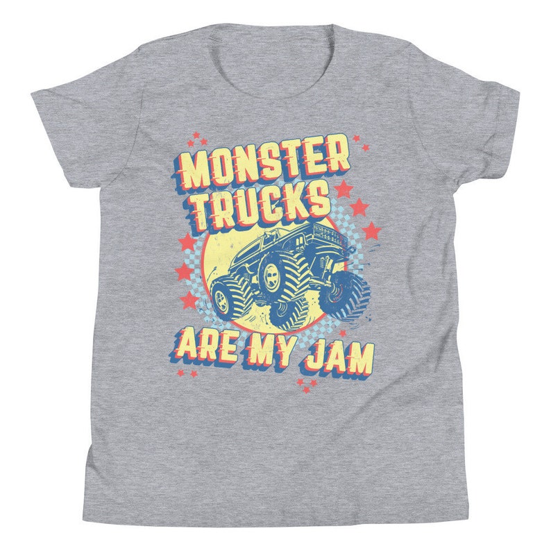 May include: A gray youth t-shirt with a vintage-style graphic of a monster truck. The graphic features the text "Monster Trucks Are My Jam" in a yellow, red, and blue color scheme.