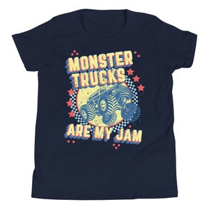 May include: A navy blue youth t-shirt with a retro-style graphic of a monster truck. The graphic features the text "Monster Trucks Are My Jam" in a yellow, red, and blue color scheme.