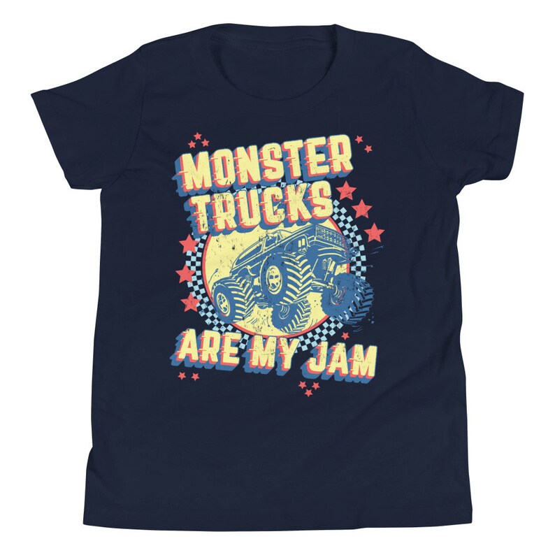 May include: A navy blue youth t-shirt with a retro-style graphic of a monster truck. The graphic features the text "Monster Trucks Are My Jam" in a yellow, red, and blue color scheme.