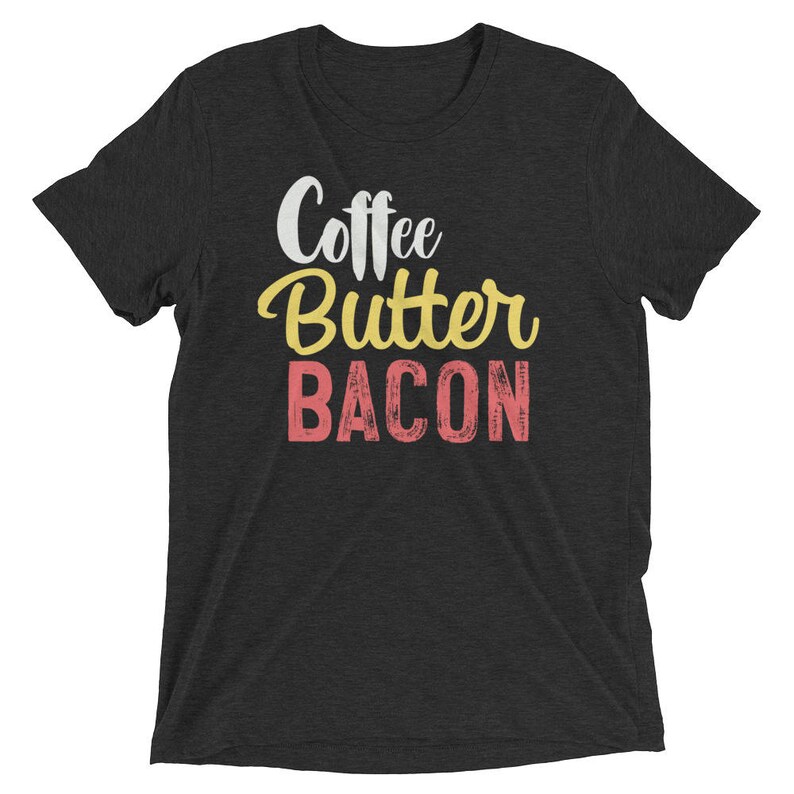 May include: A dark gray t-shirt with the text "Coffee Butter Bacon" in white, yellow, and pink lettering.