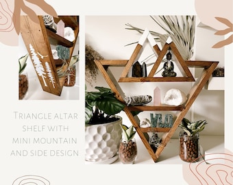 May include: Wooden triangle shelf with three tiers, featuring a mini mountain design on the top tier. The shelf is decorated with crystals, plants, and a small Buddha statue. The text "WILD" is displayed on the bottom tier.