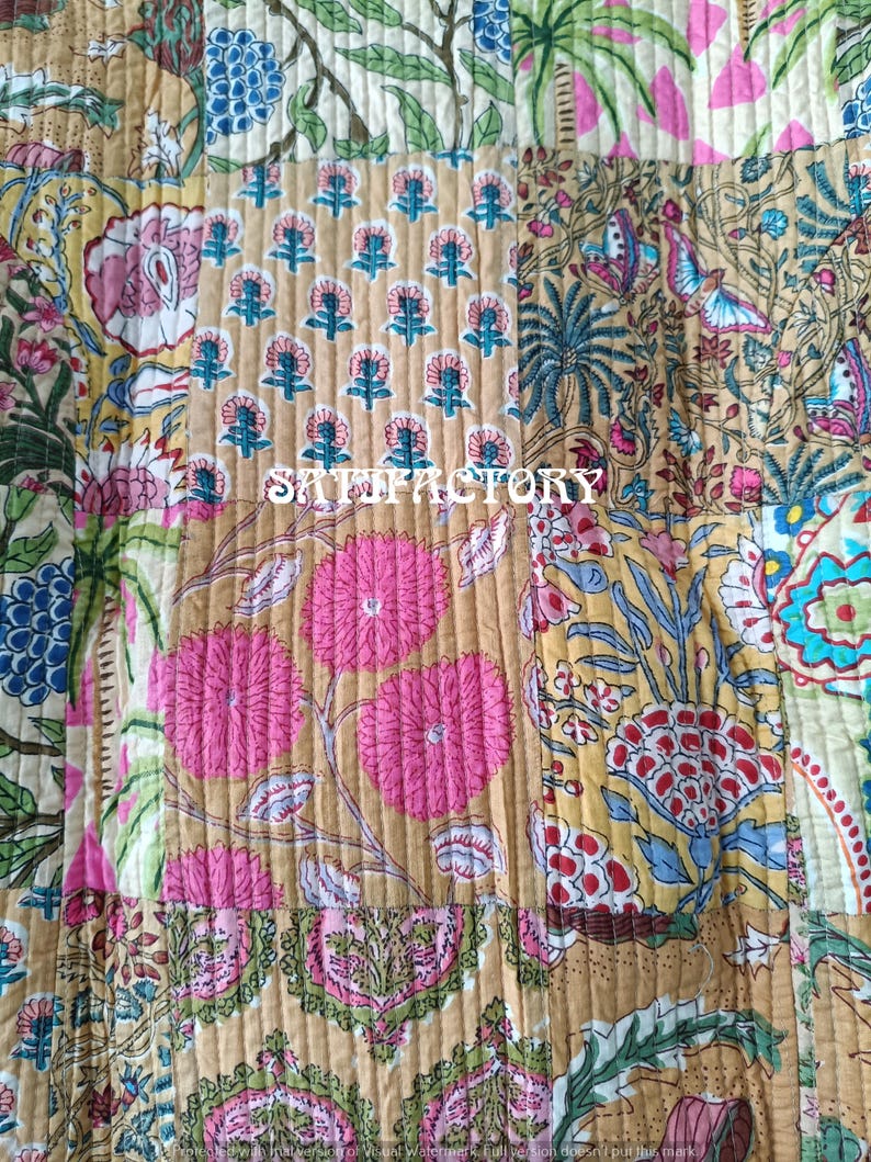 K&ouml;nnte beinhalten: Ein Patchwork-Textil mit verschiedenen floralen und botanischen Mustern in Rosa, Gr&uuml;n, Blau und Beige. Das Wort "SATISFACTORY" ist mittig aufgedruckt. Das Textil ist mit vertikalen N&auml;hten gesteppt.