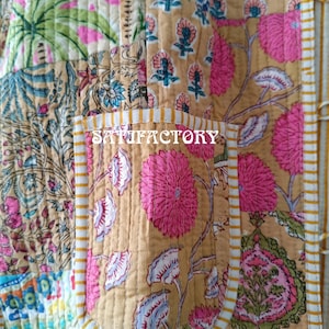 K&ouml;nnte beinhalten: Nahaufnahme eines Patchwork-Textils mit floralen und botanischen Mustern in Rosa-, Gr&uuml;n-, Blau- und Beiget&ouml;nen. Das Wort "SATISFACTORY" ist auf einer Tasche aufgedruckt. Das Textil ist mit wei&szlig;en N&auml;hten gesteppt.