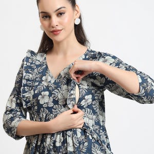 Puede incluir: Un vestido de lactancia de estampado floral azul con cuello de volantes y mangas 3/4. El vestido tiene una cremallera oculta para facilitar la lactancia.