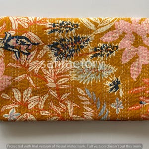 Könnte beinhalten: Senffarbener Stoff mit floralem Muster in Weiß, Rosa und Marineblau. Der Stoff weist ein sich wiederholendes Design aus Blättern und Blumen mit sichtbaren Nähten auf. Das Wort "satisfactory" ist in der Mitte des Textils sichtbar.