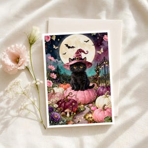 May include: A rectangular greeting card featuring a black cat wearing a pink witch hat, sitting on a large pink pumpkin. The scene includes a full moon, bats, butterflies, and various colored pumpkins in a garden setting with a decorative gate.