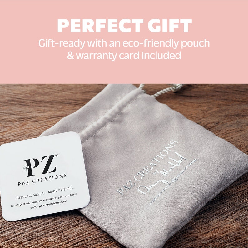 Puede incluir: Una tarjeta blanca con el texto "PZ PAZ CREATIONS" y "STERLING SILVER MADE IN ISRAEL" y "for a 2-year warranty, please register your purchase www.paz-creations.com". La tarjeta est&aacute; encima de una bolsa gris con el texto "PAZ CREATIONS Demy Ne" en ella.