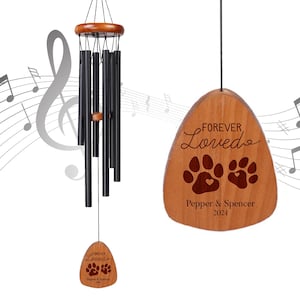 May include: A wooden wind chime with a brown, teardrop-shaped plaque that reads "FOREVER Loved" with two paw prints and the text "Pepper & Spencer 2024". The wind chime has black metal tubes.