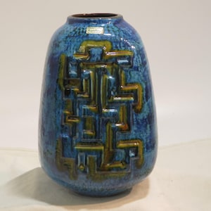 Könnte beinhalten: Eine blaue und braune Keramikvase mit geometrischem Muster. Die Vase ist mit einem Etikett versehen, auf dem "Keramik Studio Karlsruhe Germany" steht.