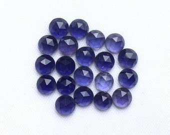 May include: A collection of 20 faceted round amethyst gemstones in shades of purple. The stones are arranged in a loose cluster on a white background.