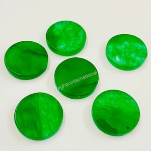 May include: Six round, green jade stones. The stones are smooth and polished, with a slight variation in color and pattern.