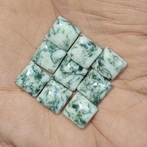 May include: A collection of seven square-cut cabochons featuring a white base with intricate, moss-like green inclusions. Each stone has a smooth, polished surface and a distinct pattern of dark green branching veins spread across the white stone.