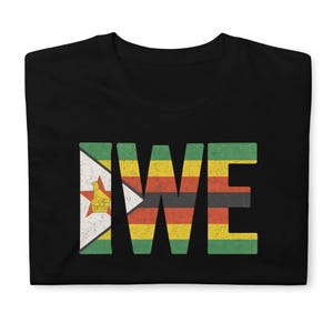 Puede incluir: Camiseta negra con la palabra "ZWE" en letras grandes y desgastadas. La "Z" presenta el diseño de la bandera de Zimbabue, con las letras restantes mostrando un patrón a rayas verdes, amarillas, rojas y negras.