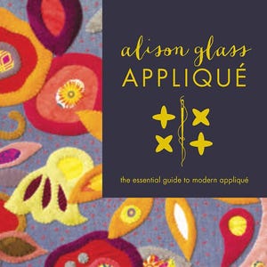 May include: A book cover with the title "alison glass APPLIQUE" in gold lettering. The cover features colorful, appliquéd fabric designs in red, yellow, purple, and pink on a blue background. The subtitle reads "the essential guide to modern appliqué."