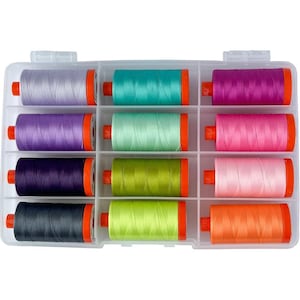 May include: A clear plastic storage case with 12 spools of thread. The spools are arranged in three rows of four. The spools are in a variety of colors, including purple, pink, green, orange, and gray.