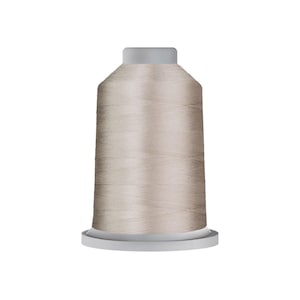 May include: A spool of light beige sewing thread featuring a smooth, cylindrical shape with a flat top and a wider base. The thread is wound tightly around the central core, displaying a consistent, neutral color throughout the entire surface.