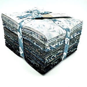 May include: A stack of 42 fat quarters of fabric in various shades of blue and gray with a white background. The fabric has a floral pattern and is tied together with a blue ribbon. The label on the top reads "Sew Easy"