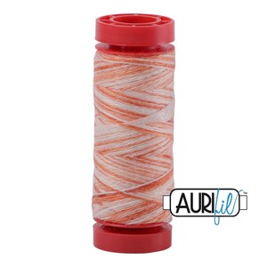 May include: A spool of variegated sewing thread featuring a blend of orange and white fibers wound around a cylindrical core. The spool has bright red plastic caps at the top and bottom. The logo for AuriFil is visible in the lower right corner.