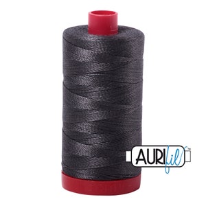 May include: A spool of dark gray thread with a red plastic bobbin and the text "Aurifil" in blue.