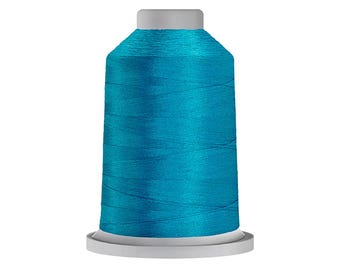 Puede incluir: Un carrete de hilo de color turquesa vibrante con un acabado brillante y reflectante. El hilo está enrollado firmemente alrededor de un núcleo cilíndrico con una base blanca plana y una tapa blanca a juego, creando un aspecto liso y uniforme.
