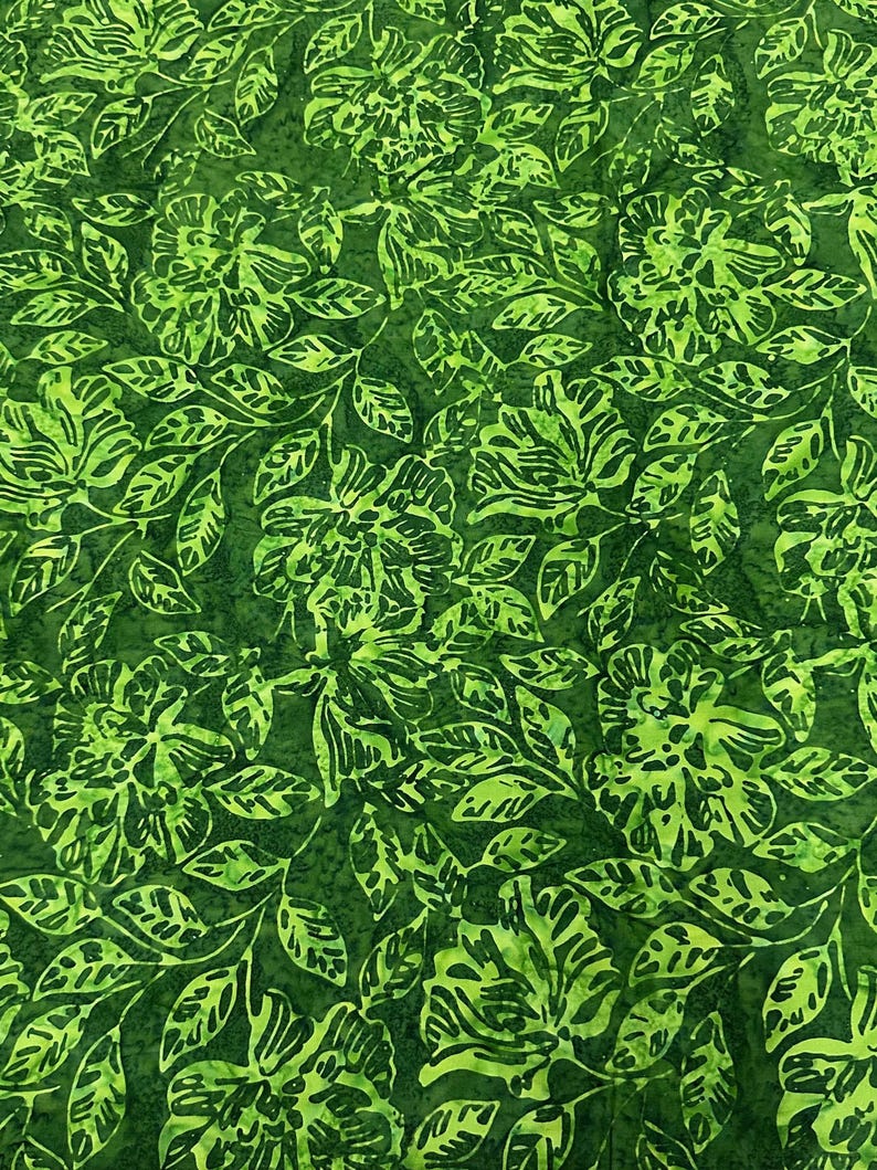 May include: Green floral fabric with a repeating pattern of stylised flowers and leaves. The fabric has a batik-like appearance.