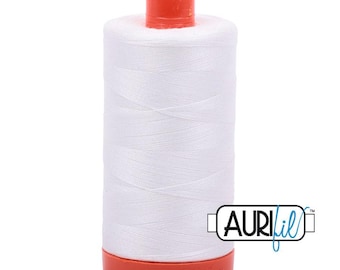May include: A cylindrical spool of white sewing thread featuring a bright orange plastic cap at the top and an orange plastic base at the bottom. The brand name AURIfil is printed in black and blue text on the lower right side of the spool.