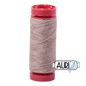 May include: A spool of beige thread with a red plastic bobbin. The thread is wound around the bobbin and is labeled "Aurifil" in blue text.