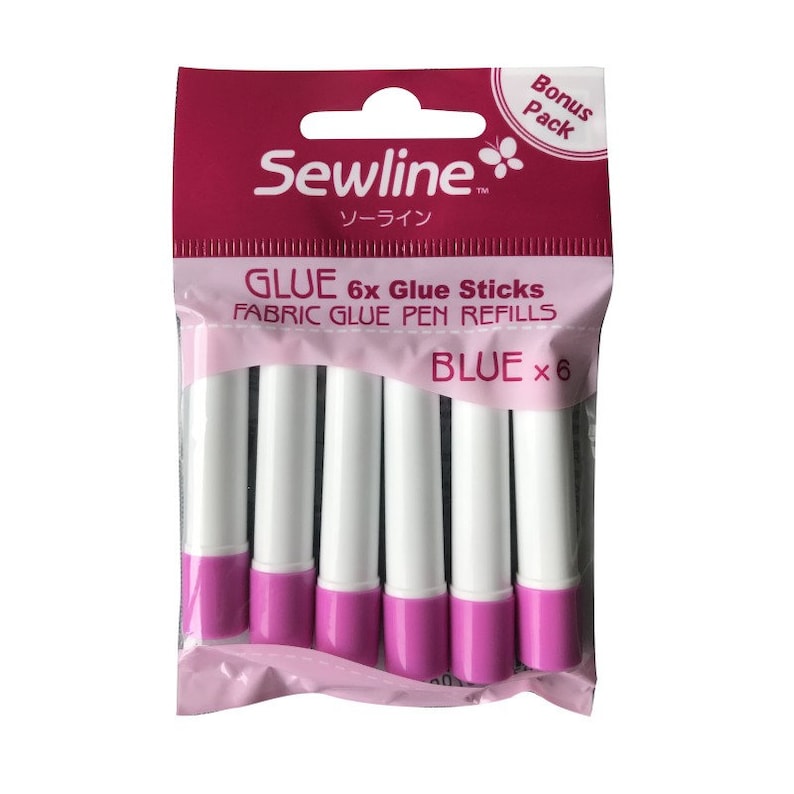 Peut inclure: Un paquet de six b&acirc;tonnets de colle bleue Sewline pour stylos &agrave; colle pour tissu. L'emballage est rose et blanc et porte les mentions "Bonus Pack" et "Sewline" avec un logo de fleur. Le texte "GLUE 6x Glue Sticks FABRIC GLUE PEN REFILLS BLUE x 6" est imprim&eacute; sur l'emballage.