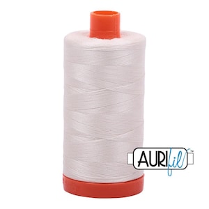 May include: A spool of light pink sewing thread wound onto a cylindrical plastic core. The spool features a bright orange top cap and a matching orange base. The brand name AuriFil is printed in black and blue text on the lower right side.