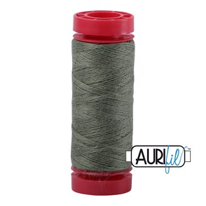 May include: A spool of green thread with a red plastic bobbin and the text "Aurifil" on the label.