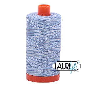 May include: A spool of blue and white striped Aurifil thread with a red plastic bobbin.