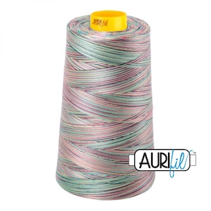 May include: A large spool of variegated sewing thread featuring a blend of light green, pink, and grey tones wrapped around a conical core. The top of the spool has a bright yellow cap with the text Auri fil printed in black lettering.