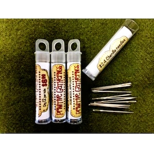 May include: Three small clear tubes with white labels that read "Primitive Gatherings for Wool Applique" and "Qty 12 per tube $6.00". A fourth tube is labeled "#24 Chenille needles". All tubes contain small, silver needles.