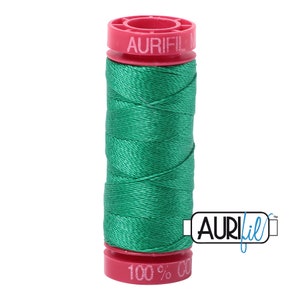 May include: A spool of green Aurifil 100% cotton thread with a pink label that says "Aurifil 100% Cotton"