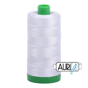 May include: A spool of light grey sewing thread with a bright green plastic top and base. The spool features a white label with the black and blue text AURIfil printed on the lower right side, indicating the brand of this polyester sewing thread.