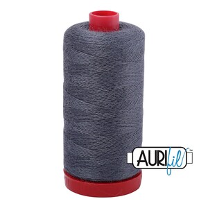 May include: A spool of dark gray sewing thread wound onto a cylindrical core with a bright red plastic top and base. The spool features a white label with the black and blue text AURIfil printed on the lower right side of the thread cylinder.