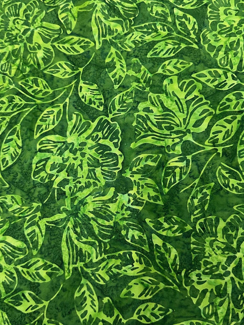 May include: Green fabric with a floral pattern. The fabric features a repeating pattern of green leaves and flowers.