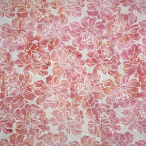 May include: A fabric featuring a repeating pattern of watercolor-style flowers in shades of pink, coral, and peach. The floral design is outlined in white, creating a stark contrast against the soft, blended colors of the petals on a white background.