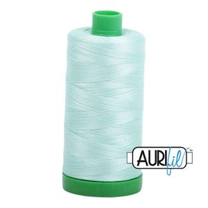 May include: A spool of light mint green sewing thread with a bright green plastic top and base. The spool features a white rectangular label with the black text AuriFil in a stylized font, positioned on the lower right side of the thread.