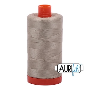 May include: A spool of light brown sewing thread with a bright orange plastic top and base. The spool features a white label with the black and blue text AURIfil printed on the side, indicating the brand of this cylindrical sewing supply item.