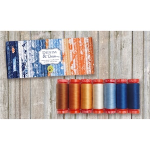 May include: A set of 7 spools of thread in various shades of blue, orange, and brown. The thread is labeled "Made in Italy". The thread is packaged in a box with a fabric design featuring a denim and daisy pattern. The box is labeled "Denim & Daisies".